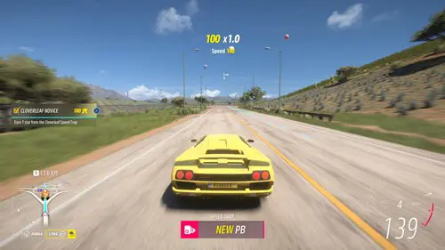 A yellow car speeds along an open road.