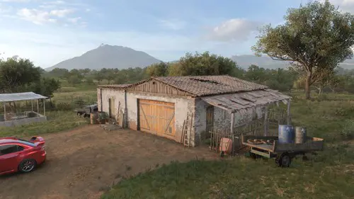 A barn with a volcano in the distant background.