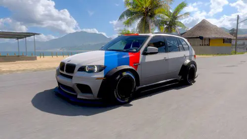 A BMW with a blue sky and sea in the background.