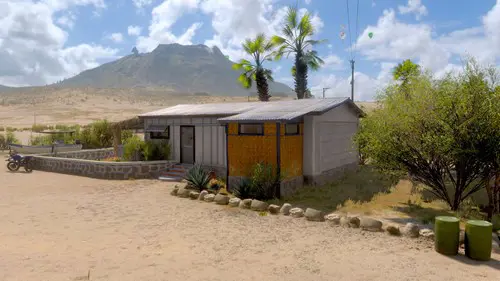 A house with a volcano in the background.