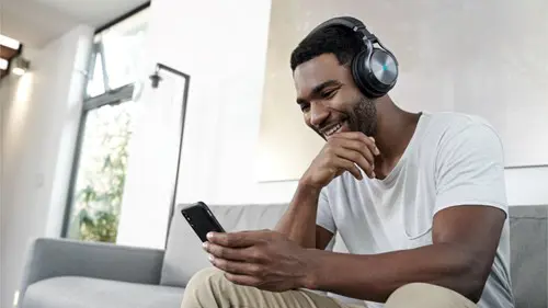 Key art of someone wearing the Corsair Virtuoso headset while on their phone