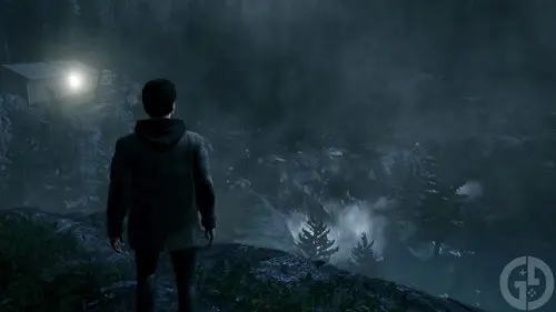 Alan Wake stands on a cliff overlooking a waterfall in Alan Wake Remastered